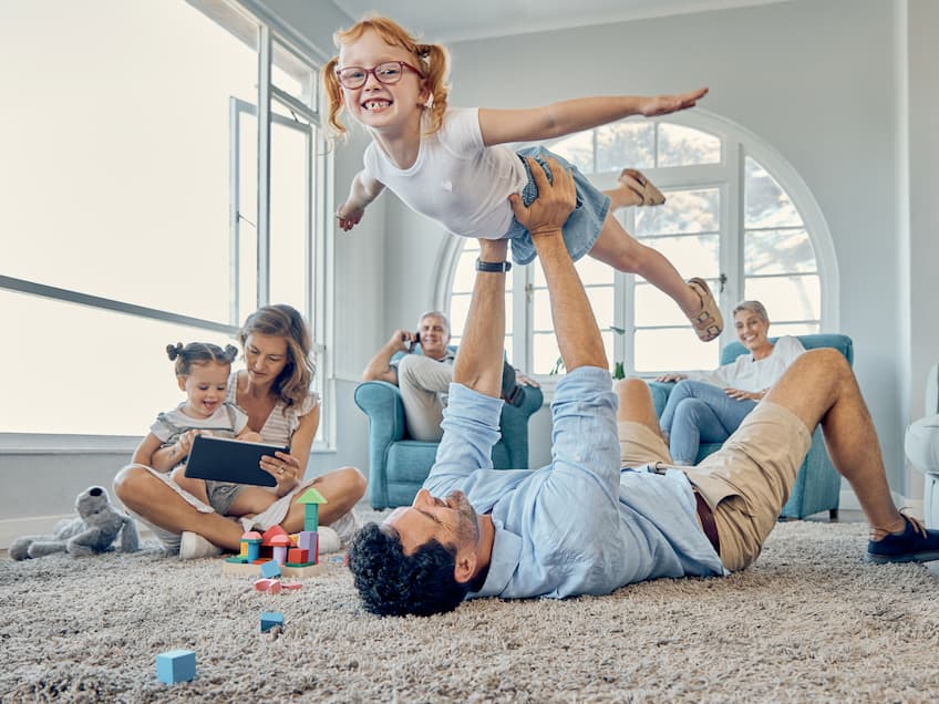 Família, protegida com a BPV Seguros, feliz e reunida na sala de estar